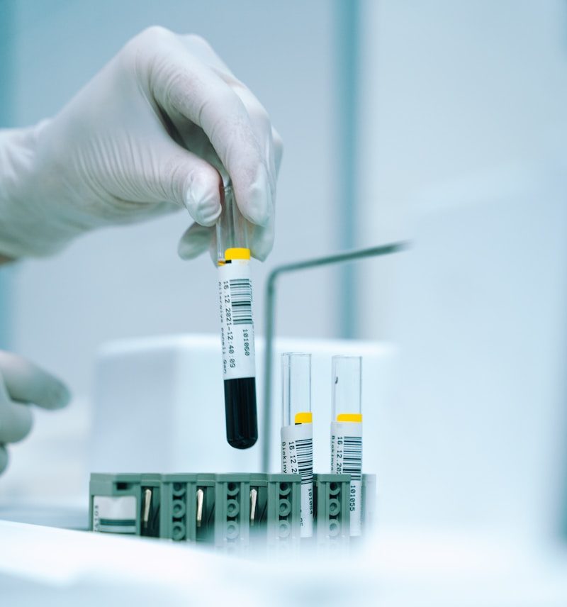 a gloved hand holding a test tube filled with liquid